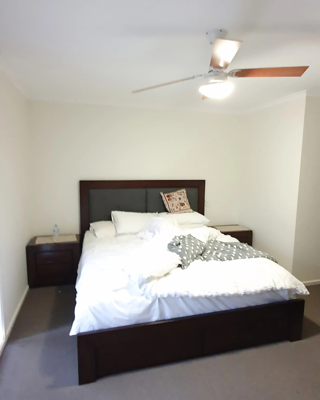 Bedroom with a bed, nightstands, and a ceiling fan, before shot. nterior stylist Melbourne, Victoria.