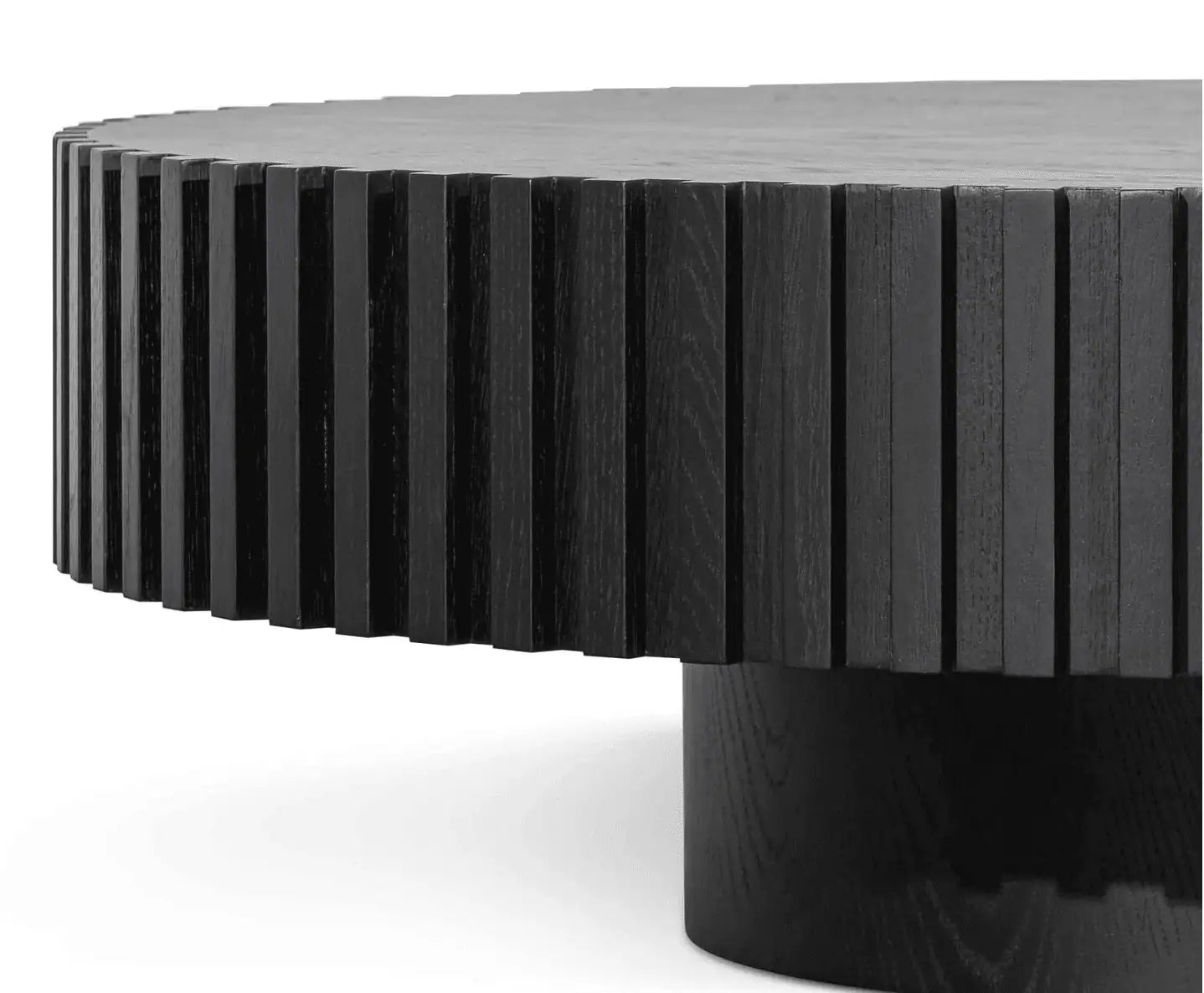 Round black table with a ribbed surface on a white background