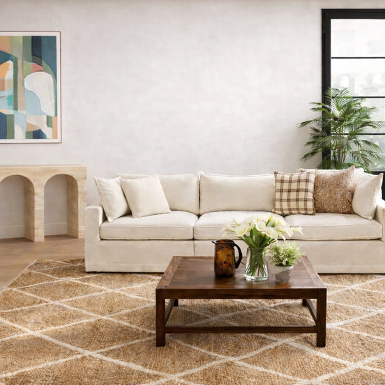 Living room with a beige sofa, coffee table, and decorative items.