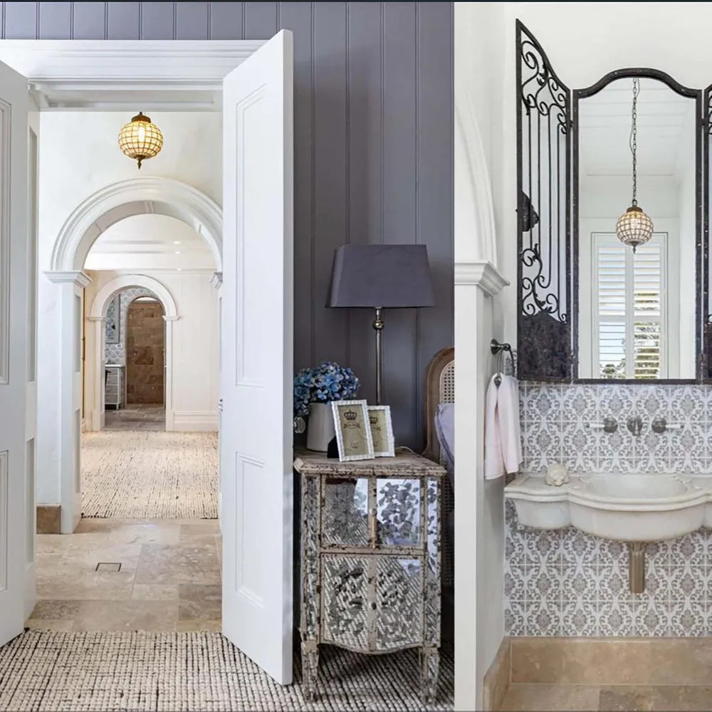 Bathroom interior with patterned tiles, mirror, and decorative elements.