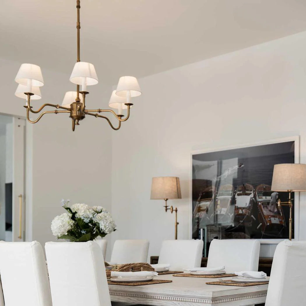 Dining room with a chandelier, table, chairs, and decorative elements.