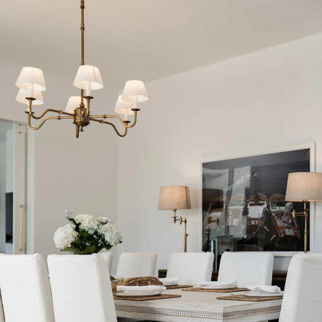 Dining room with a chandelier, table, chairs, and decorative elements.
